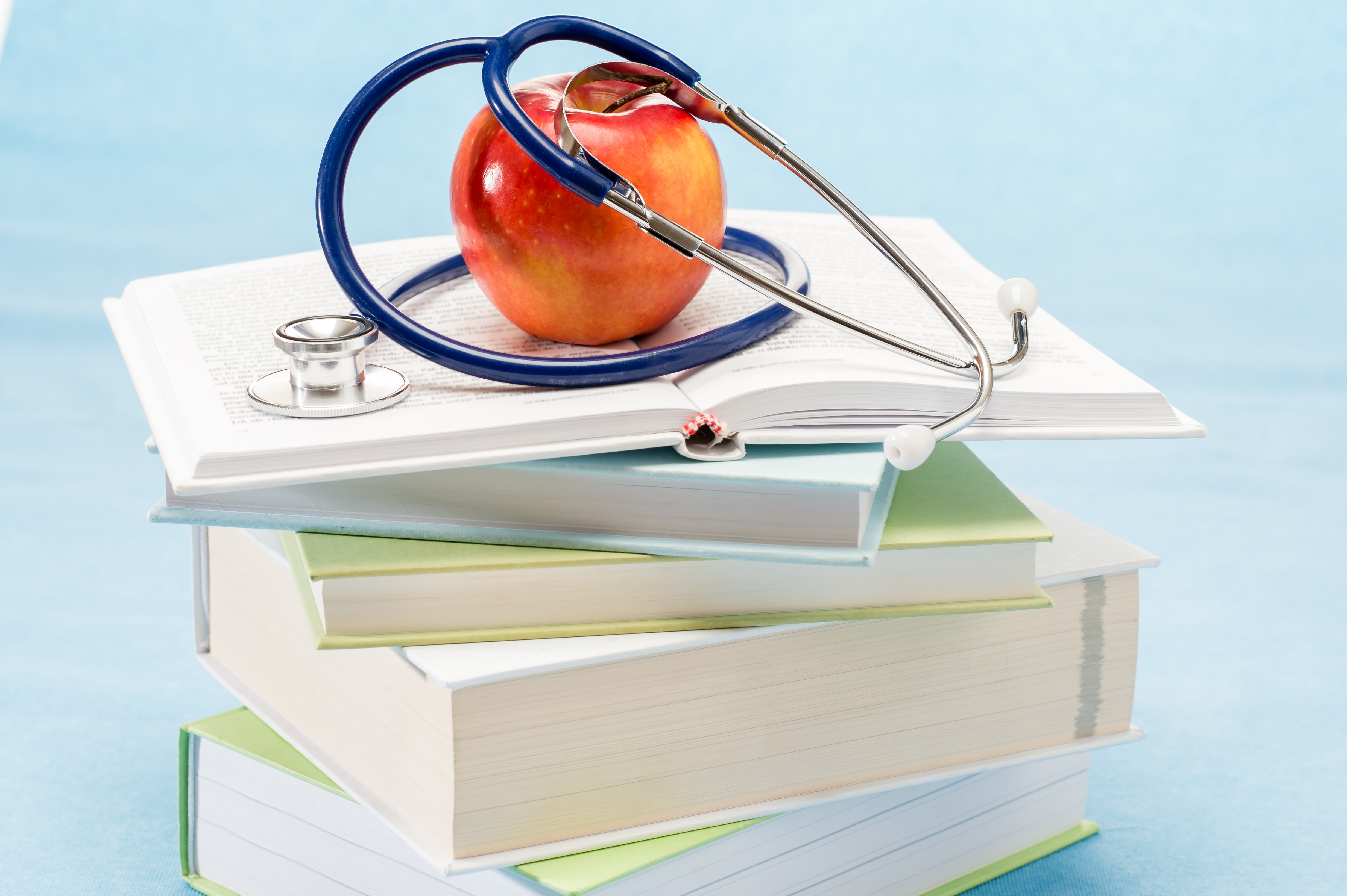 Medical Books stacked with Apple on Top