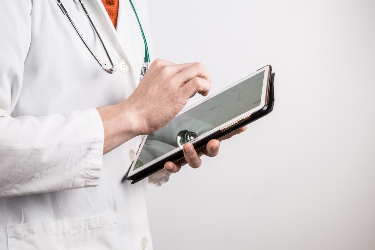 physician tapping on electronic tablet